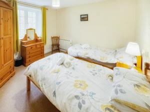 a bedroom with two beds and a dresser at Latrigg View - Uk45177 in Threlkeld