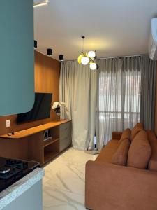 a living room with a couch and a television at Flat na BeiraMar com Piscina Privativa in Porto De Galinhas