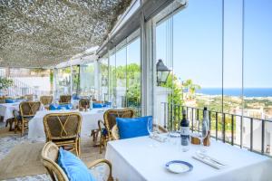 un restaurant avec tables et chaises avec vue sur l'océan dans l'établissement Hotel La Fonda, à Benalmádena