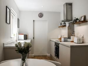 a kitchen with a vase of flowers on a table at Dinas Lodge - Uk47607 in Caernarfon