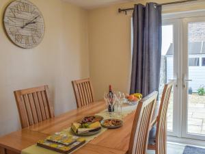 una sala da pranzo con un tavolo e un orologio a parete di Corner Cottage a Girvan