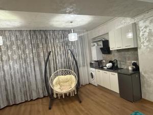 Una habitación con una silla en una cocina con una mesa. en Apartament Luxury RAL, en Mamaia