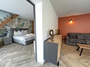 een woonkamer met een bed en een bank bij La Petite Saulaie - Proche circuit 24h - 6 pers in Changé