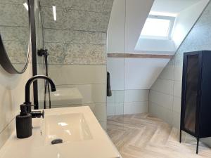 een badkamer met een wastafel en een dakraam bij La Petite Saulaie - Proche circuit 24h - 6 pers in Changé