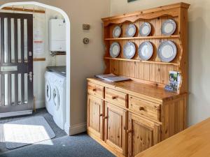 eine Waschküche mit einem Holzschrank mit Tellern darauf in der Unterkunft Marine Mews 3 - Cottage in Salcombe + 7 Fotos
