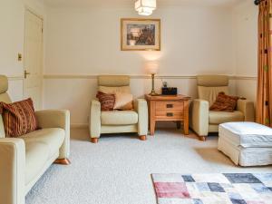 a living room with two chairs and a table at Heather Cottage in Saint Erth