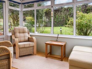 a living room with a chair and a table at Heather Cottage in Saint Erth
