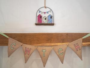 a wooden banner with a sign that says w and a house at Ty Canol in Bridell