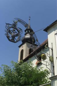 a building with a tower with a clock on it at Zum Schwarzen Adler in Mainberg