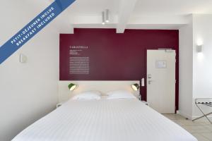 a bedroom with a white bed and a purple wall at Hôtel Les Voiles in Toulon