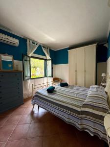 a bedroom with a bed with blue walls and a window at Villa Giulia in Parghelia