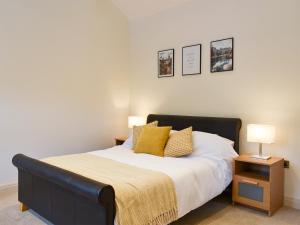 a bedroom with a bed with yellow pillows on it at Swaledale Cottage - Barley Green Mill in Barrowford