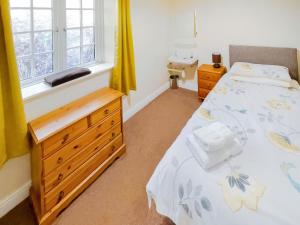 a bedroom with a bed with a dresser and a window at Latrigg View - Uk45177 in Threlkeld +2 photos
