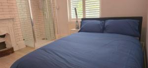 een blauw bed in een slaapkamer met een open haard bij 8 Guests - Free Parking - Full Equipped House in Saint Helens