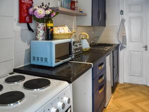 a kitchen with a stove and a microwave at Seaglass Chalet - Uk47636 in Mundesley