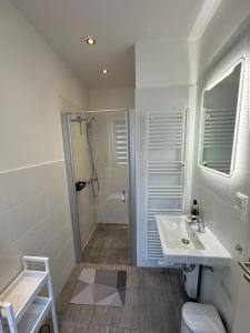a white bathroom with a sink and a shower at Bungalow Benther Berg, Contactless Check-in, Vollsaniert und Renoviert 2025 in Ronnenberg +20 photos