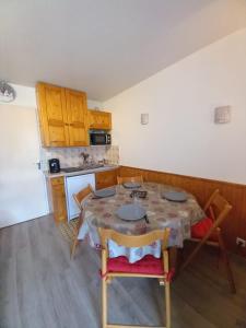 une cuisine avec une table et des chaises dans une pièce dans l'établissement Bel appartement Samoens La Cour classe 2 etoiles, à Samoëns 2 autres photos