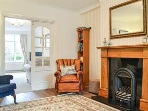 a living room with a chair and a fireplace at Parkfield in Keswick