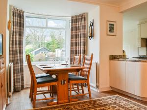 a dining room with a table and chairs and a window at Parkfield in Keswick +15 photos