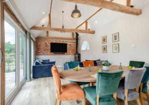 une salle à manger avec une table et des chaises en bois dans l'établissement Iken Barn, à Neatishead