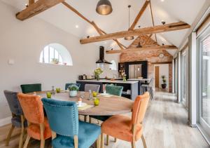 une cuisine et une salle à manger avec une table et des chaises en bois dans l'établissement Iken Barn, à Neatishead