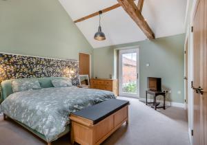 une chambre avec un grand lit et une cheminée dans l'établissement Iken Barn, à Neatishead 12 autres photos