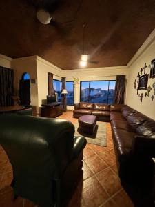 a living room with leather furniture and a large window at The House of Angels in Las Conchas