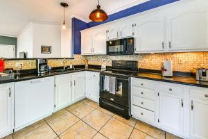 a kitchen with white cabinets and black appliances at 10 Mi to Keeneland Family Home with Deck and Yard in Lexington