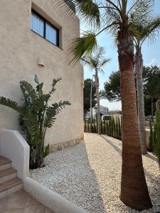 a house with palm trees next to a building at Casa Bel - Apartment 3 in Miami Platja