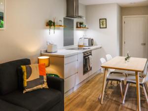 a kitchen with a couch and a table in a room at Menai Lodge - Uk47604 in Caernarfon