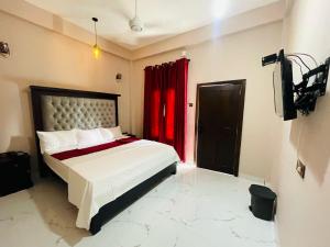 a bedroom with a bed with a red curtain at Mango Mansion in Jaffna