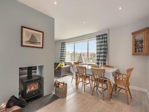 a dining room with a table and chairs and a fireplace at Little Dab in Brancaster