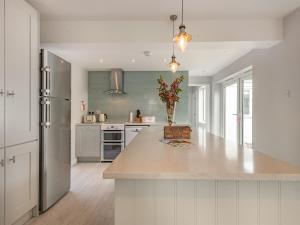a kitchen with white cabinets and a large counter top at Little Dab in Brancaster