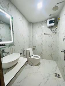a white bathroom with a sink and a toilet at Mango Mansion in Jaffna +10 photos