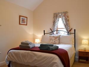 ein Schlafzimmer mit einem Bett mit Handtüchern darauf in der Unterkunft Brampton Hill Farm Cottage in Madley