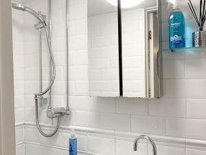 a shower in a bathroom with a mirror at Fisherman's Cottage in Plymouth +9 photos