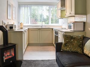 a kitchen with a stove and a kitchen with a fireplace at Holly Hideaway - Cottage in Troutbeck Bridge