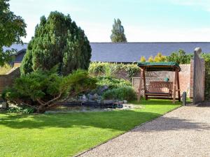 a garden with a pond and a gazebo at Lake House Cottage in Finchingfield