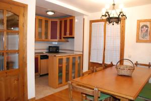 a kitchen with a wooden table and a dining room at Casa Rural Janet in Izalzu