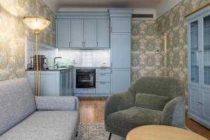 a living room with a couch and a chair and a table at Roze Boutique Apartments in Liepāja