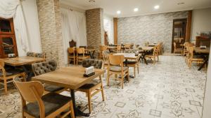 a restaurant with wooden tables and chairs and brick walls at Uz Hotel Premium in Safranbolu