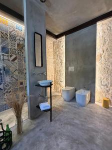 a bathroom with two toilets and a sink and a tub at Papalei La Maison in Ragusa