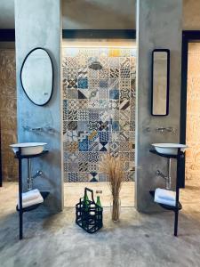 a bathroom with two sinks and a mosaic wall at Papalei La Maison in Ragusa +56 photos