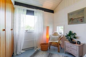 a room with a window and a chair and a table at Feriehus Perlen Tversted in Bindslev