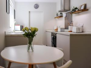 a vase of flowers on a white table in a kitchen at Dinas Lodge - Uk47607 in Caernarfon