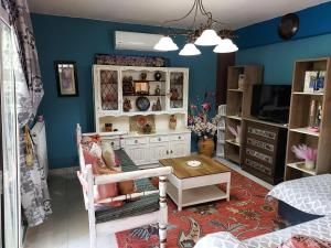 a living room with blue walls and a white cabinet at MV House Goulediana Rethymno in Rethymno