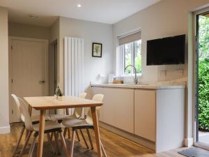 a kitchen and dining room with a table and chairs at Menai Lodge - Uk47604 in Caernarfon