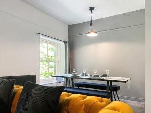a living room with a table and a yellow couch at Pavilion Mews in Buxton