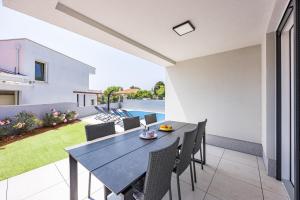 a dining room with a table and chairs on a patio at Peninsula Villas in Premantura