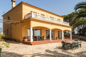 a yellow house with a table and chairs at Villa Roselles in Lloret de Mar